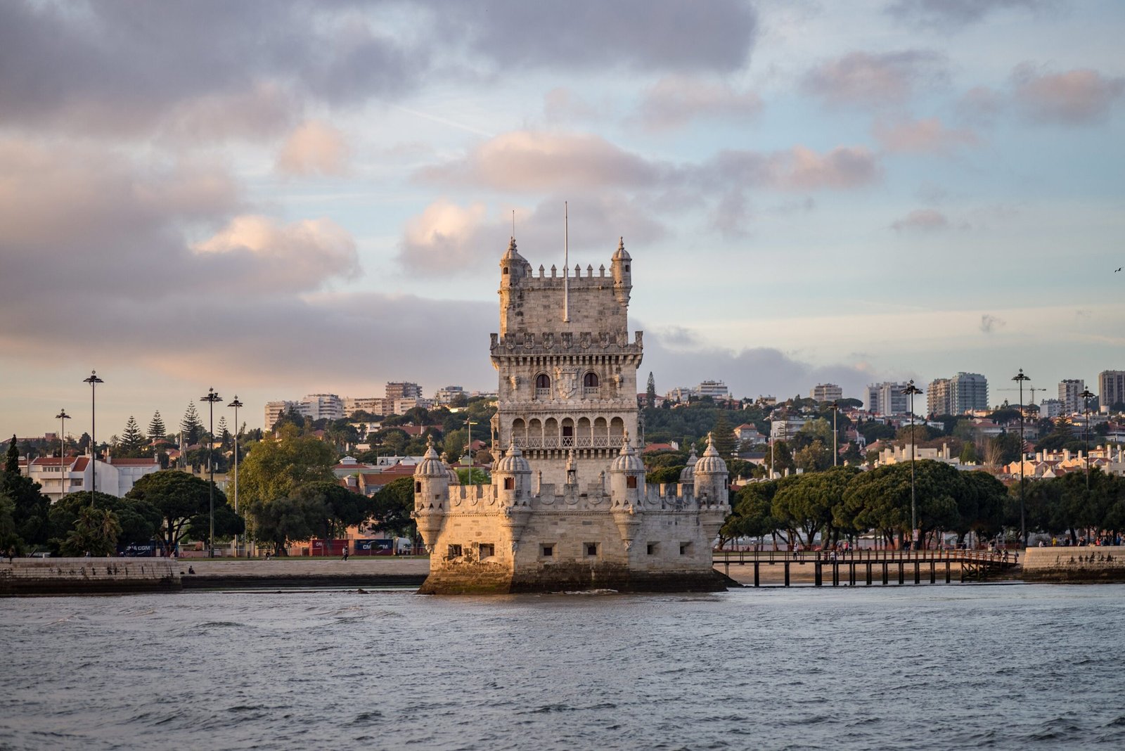tower belem surrounded by sea buildings cloudy sky portugal scaled